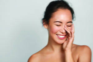 woman with clear skin smiling after facial